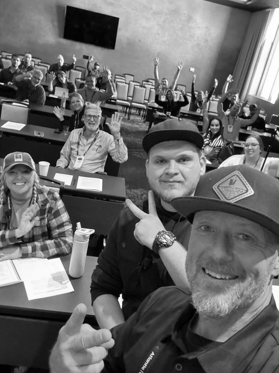 Isaac Mashman with attendees at the Atlantic-Oase Professional Conference, the room raising their hands behind them