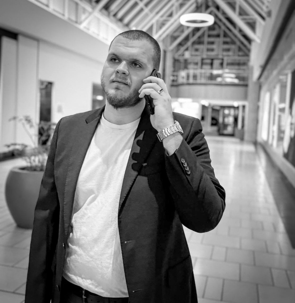 Isaac Mashman on a phone call in a mall concourse